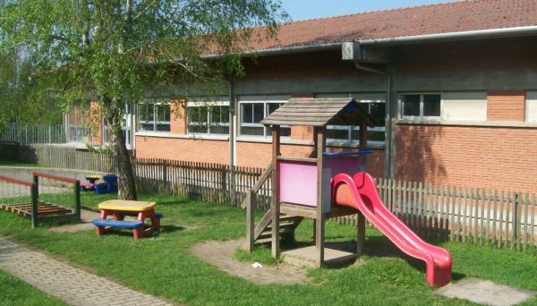 Esterno della scuola con scivolo, tavolo, spazio verde