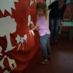 Bambina che incolla gli elementi della creazione