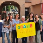 La maestra Adolfa e le colleghe con un cartello giallo con la scritta Grazie