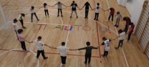 La scritta Ti aiuto realizzata con gli attrezzi della palestra
