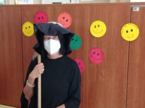 una maestra vestita da strega con il cappello e la scopa