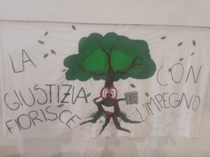 Albero con la scritta La giustizia fiorisce con l'impegno