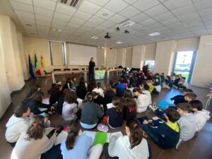 Bambini seduti per terra davanti alla scrittrice