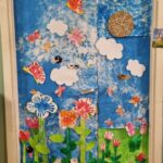 Porta ricoperta da fiori colorati e cielo azzurro