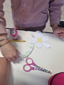mani di bambini, un fiore di carta e un paio di forbici