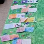 cartellone verde con appoggiati disegni