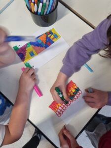 mani di bambini che colorano dei segnalibri