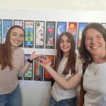 Parete con i sognalibro appesi al muro, davanti ci sono tre persone