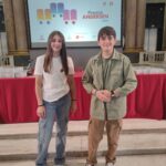 due ragazzi in piedi davanti ad un tavolo decorato con una tovaglia