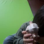 bambino con una conchiglia appoggiata all'orecchio destro