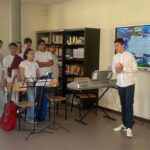 tre ragazzi in piedi davanti ad una lavagna con la scritta benvenuti nella regione sud orientale