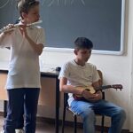 una ragazza suona il flauto, un ragazzo con l'ukulele