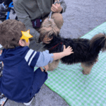 un bambino accovacciato accarezza un cane