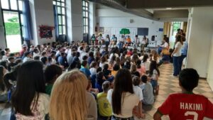 i ragazzi seduti per terra, davanti a loro un alcuni ragazzi seduti sulle sedie