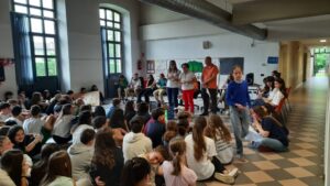ragazzi seduti per terra, davani a loro alcuni ragazzi in piedi