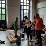 un ragazzo prende un foglio dalle mani di un adulto