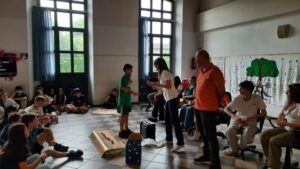 un ragazzo prende un foglio dalle mani di un adulto