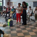 due insegnanti in piedi dietro ad una scatola di cartone